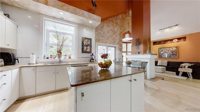6097 Wellesley Cmn, Clarence, NY 14051 - kitchen with track lighting, a center island, dark stone counters, and white cabinets