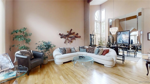 6097 Wellesley Cmn, Clarence, NY 14051 - living room featuring a chandelier, a high ceiling, and wood finished floors