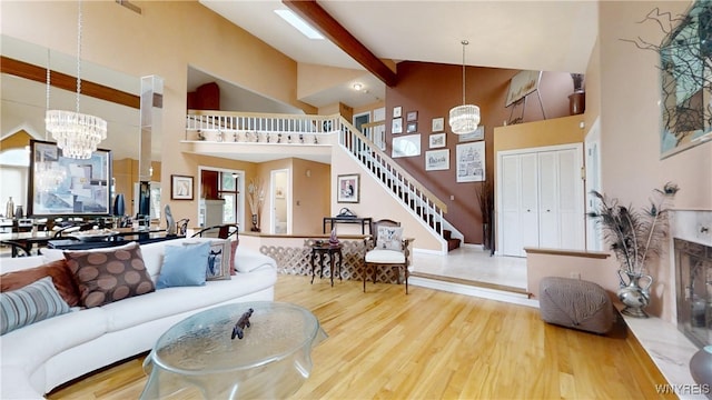 6097 Wellesley Cmn, Clarence, NY 14051 - living room featuring high vaulted ceiling, wood finished floors, stairway, and a chandelier