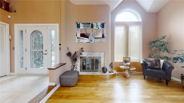 6097 Wellesley Cmn, Clarence, NY 14051 - foyer with wood finished floors, a tiled fireplace, and high vaulted ceiling