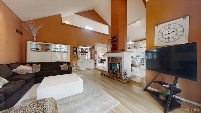 6097 Wellesley Cmn, Clarence, NY 14051 - living area with wood finished floors, high vaulted ceiling, and a fireplace
