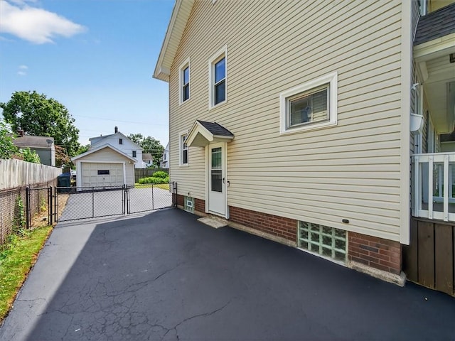 55 Morville Dr, Rochester, NY 14615 - view of side of home featuring a detached garage, an outdoor structure, and a gate