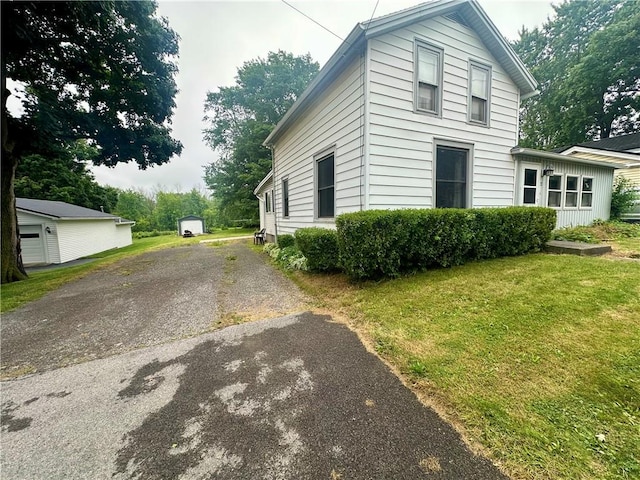 22 N Main St, Elba, NY 14058 - view of side of home featuring asphalt driveway and a lawn