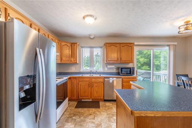 11 Wenrich Cir, Henrietta, NY 14586 - kitchen with stainless steel appliances, dark countertops, a textured ceiling, brown cabinetry, and stone finish floors