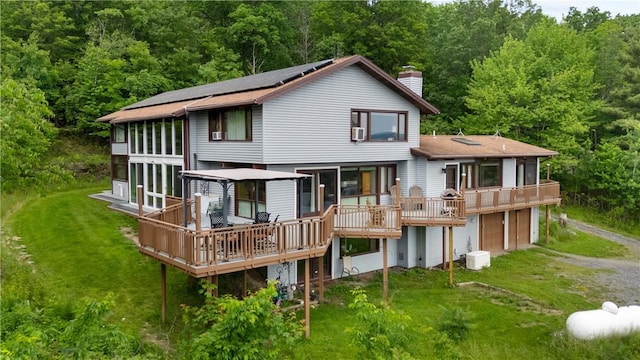 4570 Vine Rd, Jerusalem, NY 14527 - back of house featuring a chimney, driveway, a wooden deck, an attached garage, and a yard