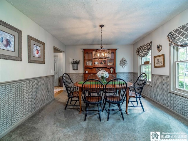 5616 Stow Rd, North Harmony, NY 14710 - dining area featuring wallpapered walls, a wainscoted wall, carpet flooring, a chandelier, and a textured ceiling