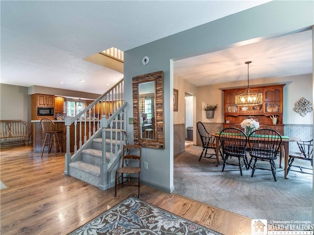 5616 Stow Rd, North Harmony, NY 14710 - dining room featuring wood finished floors, stairs, and a chandelier