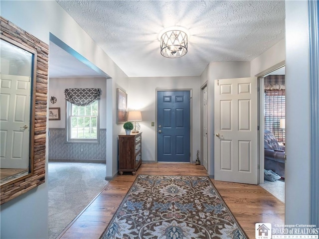 5616 Stow Rd, North Harmony, NY 14710 - entrance foyer with a textured ceiling, wood finished floors, and a chandelier