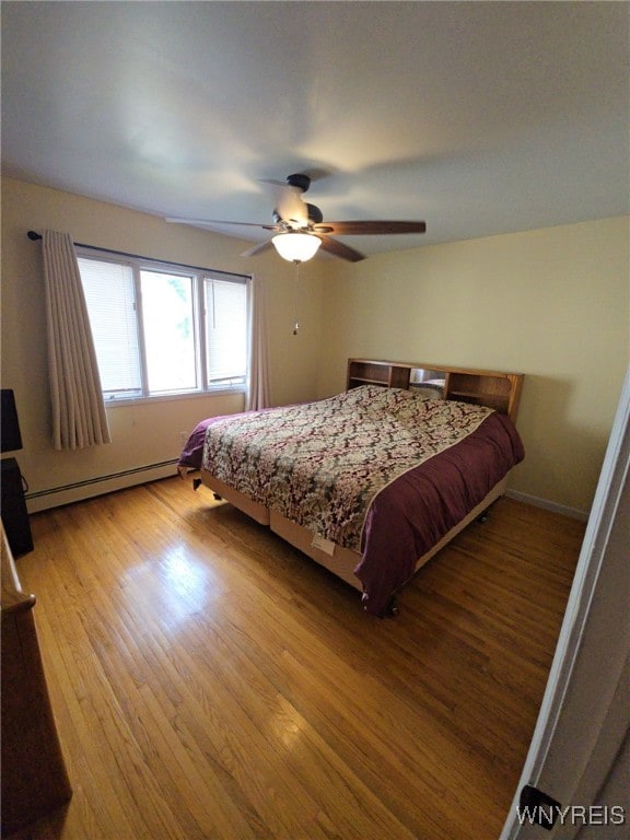 4947 Seneca St, West Seneca, NY 14224 - bedroom with a baseboard radiator, wood finished floors, and a ceiling fan