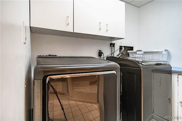 4947 Seneca St, West Seneca, NY 14224 - laundry area featuring cabinet space, separate washer and dryer, and light tile patterned floors
