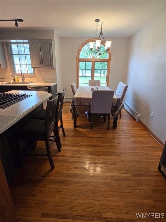 4947 Seneca St, West Seneca, NY 14224 - dining room with dark wood-style floors, a chandelier, and a baseboard heating unit