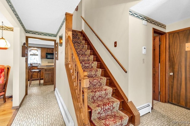 1581 N Forest Rd, Amherst, NY 14221 - staircase with a baseboard radiator, a textured ceiling, and tile patterned floors
