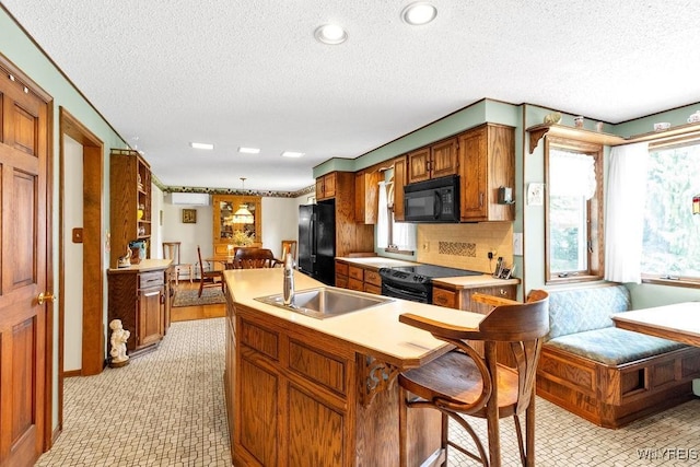 1581 N Forest Rd, Amherst, NY 14221 - kitchen with black appliances, a textured ceiling, light countertops, brown cabinets, and tasteful backsplash