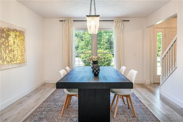 151 Crab Apple Ln, Greece, NY 14626 - dining room featuring wood finished floors, healthy amount of natural light, stairs, and a textured ceiling