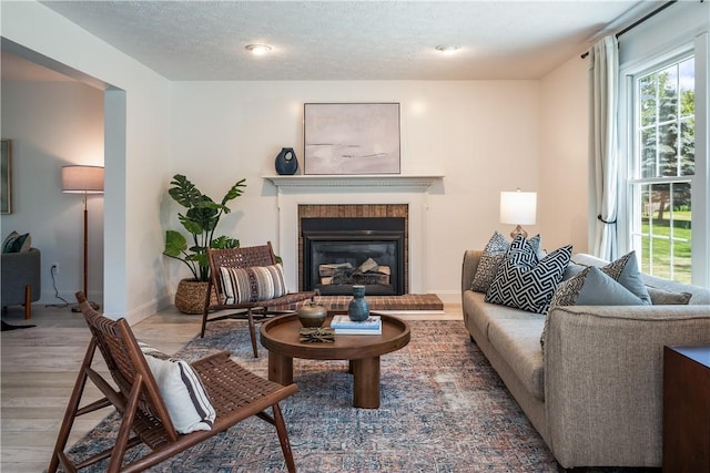 151 Crab Apple Ln, Greece, NY 14626 - living room featuring wood finished floors, a brick fireplace, and a textured ceiling