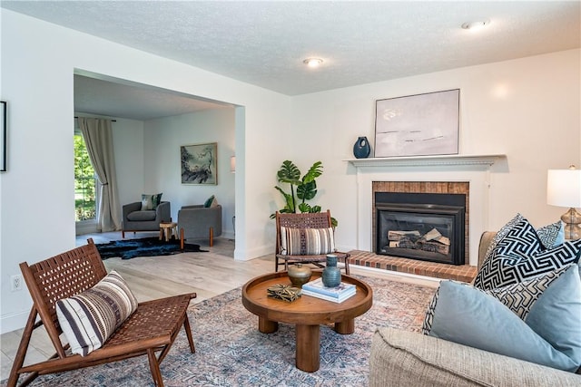 151 Crab Apple Ln, Greece, NY 14626 - living area with light wood-style flooring, a fireplace, and a textured ceiling