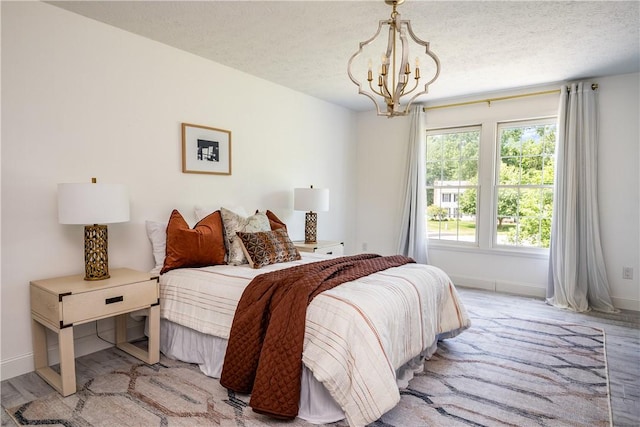 151 Crab Apple Ln, Greece, NY 14626 - bedroom featuring a chandelier, light wood-type flooring, and a textured ceiling