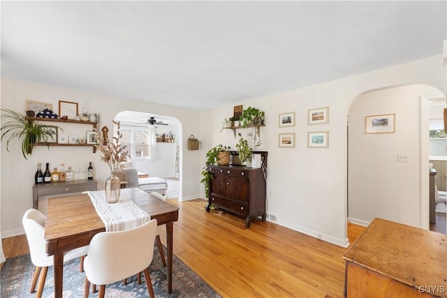 102 Bramley Dr, Camillus, NY 13031 - dining area featuring arched walkways, light wood-type flooring, plenty of natural light, and ceiling fan