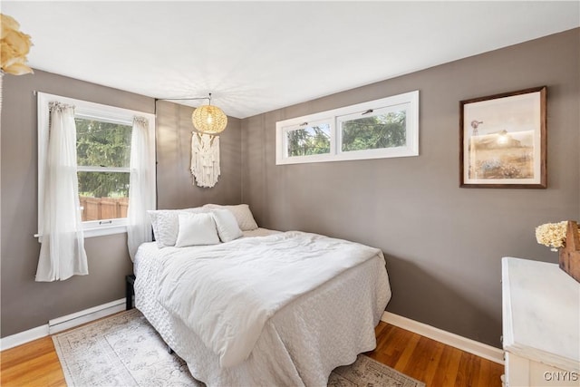 102 Bramley Dr, Camillus, NY 13031 - bedroom featuring multiple windows, wood finished floors, and baseboard heating