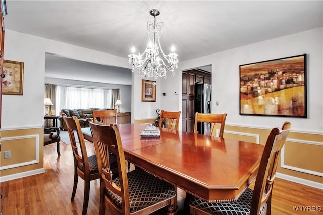 204 Belvoir Rd, Amherst, NY 14221 - dining room featuring a chandelier, light wood-type flooring, and a wainscoted wall