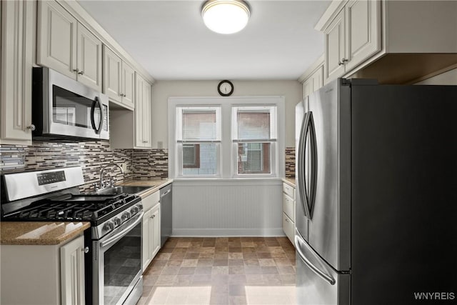 532 Linden Ave, Buffalo, NY 14216 - kitchen featuring appliances with stainless steel finishes, decorative backsplash, light stone countertops, and wainscoting