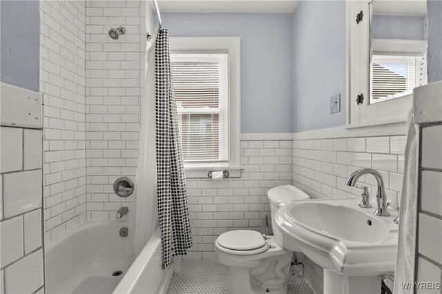 532 Linden Ave, Buffalo, NY 14216 - bathroom featuring shower / tub combo with curtain, wainscoting, tile patterned flooring, and tile walls
