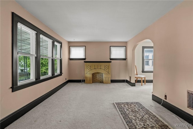 532 Linden Ave, Buffalo, NY 14216 - unfurnished living room with light carpet, plenty of natural light, arched walkways, and a brick fireplace