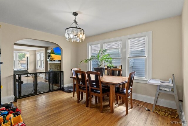 532 Linden Ave, Buffalo, NY 14216 - dining space featuring arched walkways, light wood finished floors, and a chandelier