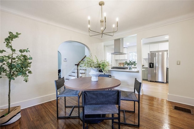 240 Sagamore Dr, Irondequoit, NY 14617 - dining space with arched walkways, light wood-type flooring, a chandelier, crown molding, and stairs