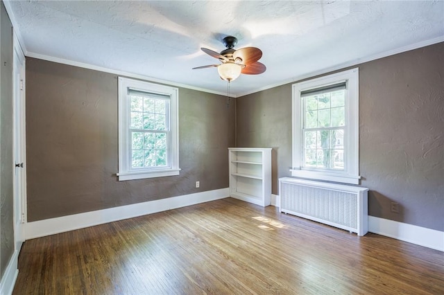 240 Sagamore Dr, Irondequoit, NY 14617 - empty room featuring radiator heating unit, wood finished floors, plenty of natural light, a ceiling fan, and ornamental molding