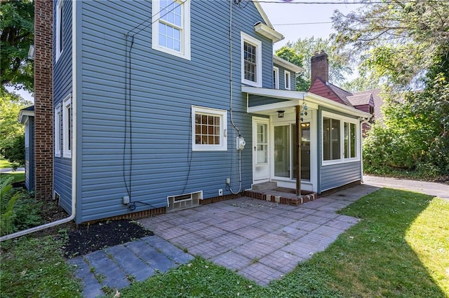 240 Sagamore Dr, Irondequoit, NY 14617 - rear view of house with a patio, a sunroom, a yard, and a chimney