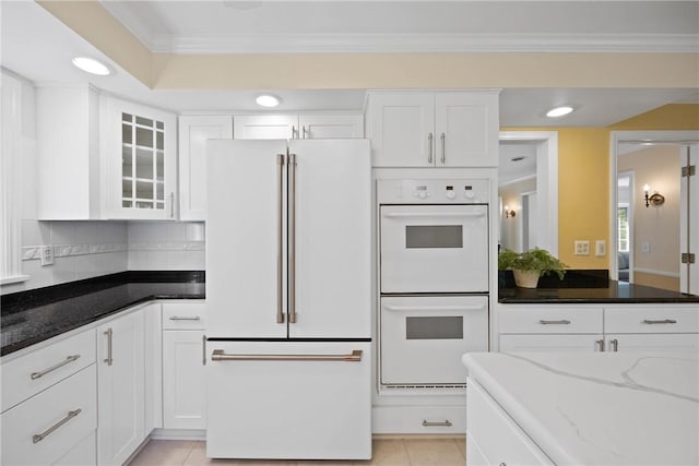 3 Tuxford Rd, Pittsford, NY 14534 - kitchen featuring white appliances, white cabinetry, dark stone countertops, ornamental molding, and glass insert cabinets