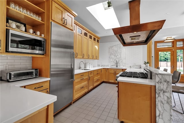 7 Lebrun Cir, Amherst, NY 14226 - kitchen featuring appliances with stainless steel finishes, a skylight, a peninsula, decorative backsplash, and light countertops