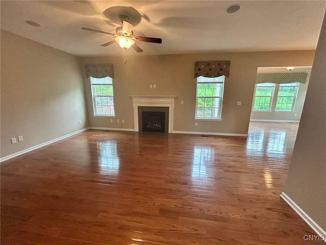 107 Shaker Hts, Camillus, NY 13031 - unfurnished living room featuring healthy amount of natural light, a ceiling fan, wood finished floors, and a fireplace with flush hearth