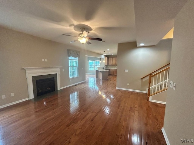 107 Shaker Hts, Camillus, NY 13031 - unfurnished living room with dark wood-style flooring, stairway, a ceiling fan, a fireplace with flush hearth, and recessed lighting
