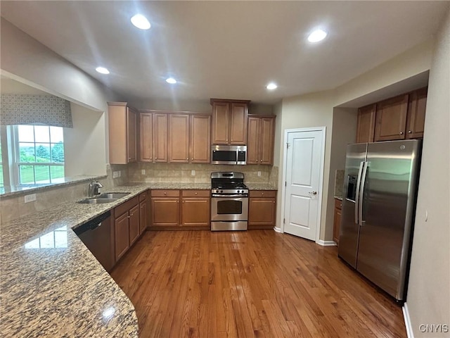 107 Shaker Hts, Camillus, NY 13031 - kitchen featuring appliances with stainless steel finishes, wood finished floors, backsplash, recessed lighting, and light stone countertops
