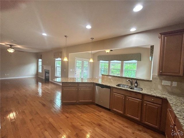107 Shaker Hts, Camillus, NY 13031 - kitchen featuring dishwasher, open floor plan, wood finished floors, light stone counters, and a glass covered fireplace