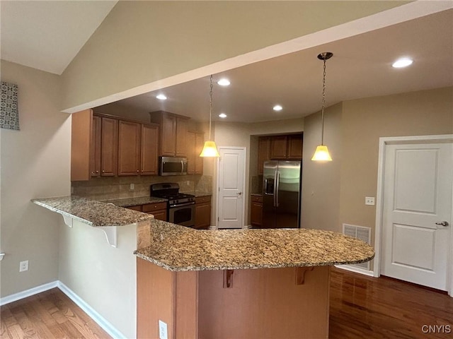 107 Shaker Hts, Camillus, NY 13031 - kitchen with stainless steel appliances, a peninsula, wood finished floors, a kitchen breakfast bar, and vaulted ceiling