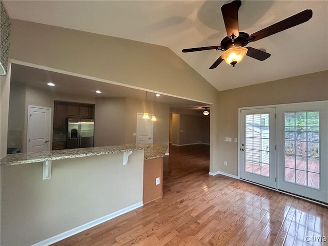107 Shaker Hts, Camillus, NY 13031 - kitchen with stainless steel fridge, a ceiling fan, a breakfast bar, light wood-style floors, and vaulted ceiling