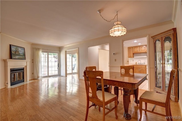 1175 Youngs Rd Unit C, Amherst, NY 14221 - dining area with crown molding, light wood-type flooring, and a fireplace with flush hearth