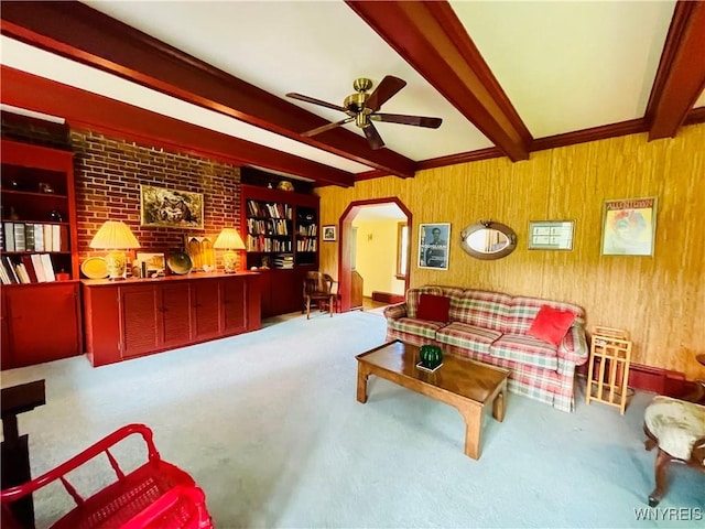 2721 Bowen Rd, Elma, NY 14059 - living area with beam ceiling, a ceiling fan, arched walkways, carpet flooring, and wood walls