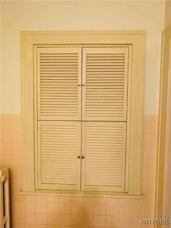 2721 Bowen Rd, Elma, NY 14059 - detailed view of radiator heating unit, tile walls, and wainscoting