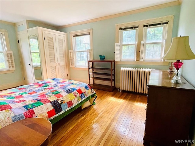 2721 Bowen Rd, Elma, NY 14059 - bedroom with radiator heating unit, multiple windows, light wood finished floors, a closet, and ornamental molding