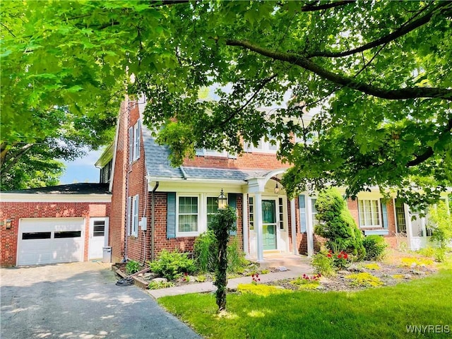 2721 Bowen Rd, Elma, NY 14059 - view of property hidden behind natural elements featuring brick siding, a garage, a chimney, driveway, and a shingled roof