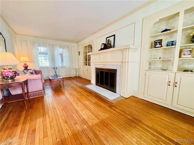 2721 Bowen Rd, Elma, NY 14059 - living area featuring built in shelves, light wood-style flooring, crown molding, and a glass covered fireplace