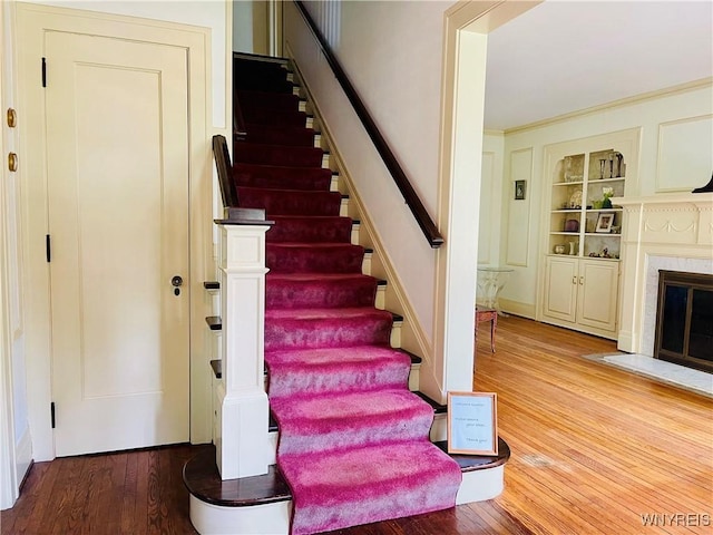 2721 Bowen Rd, Elma, NY 14059 - stairway featuring wood finished floors, a fireplace with flush hearth, and built in shelves