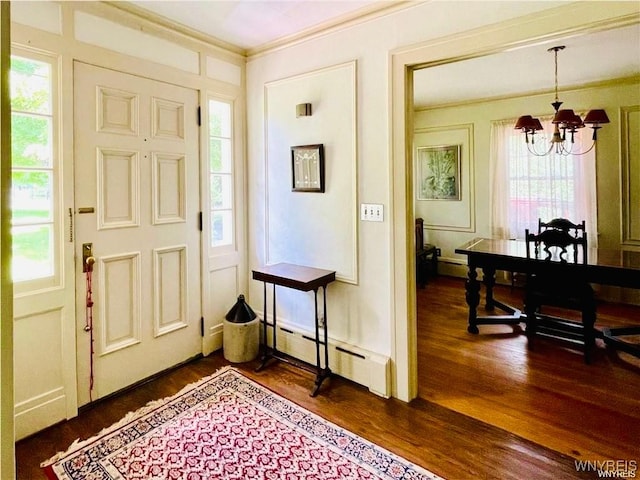 2721 Bowen Rd, Elma, NY 14059 - foyer entrance with baseboard heating, a chandelier, ornamental molding, and dark wood finished floors