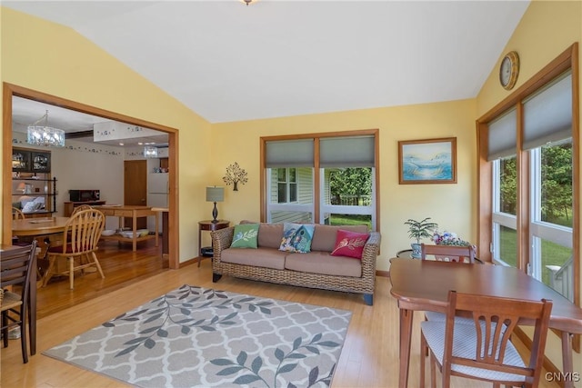 206 Oswego River Rd, Schroeppel, NY 13135 - living area featuring vaulted ceiling, wood finished floors, and a chandelier