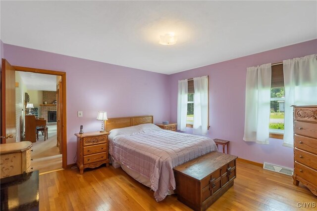 206 Oswego River Rd, Schroeppel, NY 13135 - bedroom featuring light wood-type flooring and a fireplace