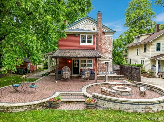 626 Main St, Porter, NY 14174 - rear view of property featuring an outdoor fire pit, a patio area, a chimney, and brick siding
